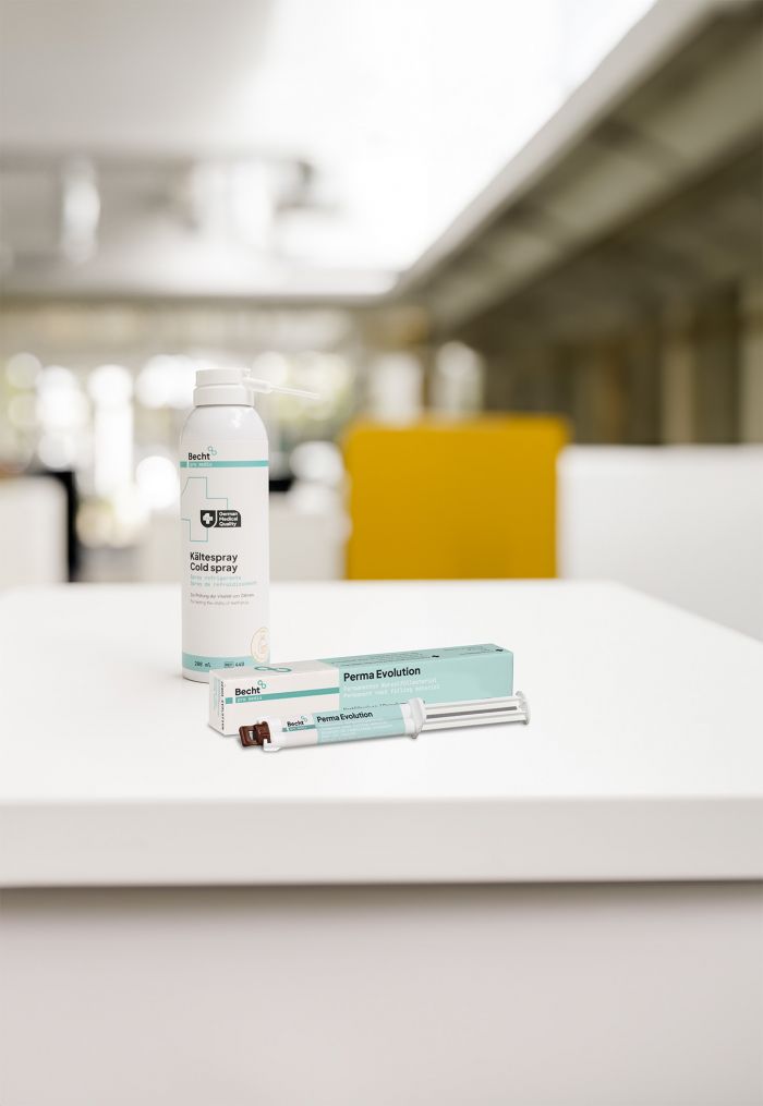 Becht cold spray and Perma Evolution root filling material on a white table in a modern dental office. The products are used for pulp vitality testing and permanent root canal fillings in endodontics.