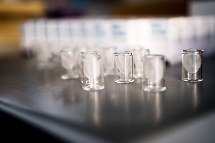 Transparente Glasbehälter aus der Produktion der Alfred Becht GmbH stehen in Reihen bereit für die weitere Verarbeitung.