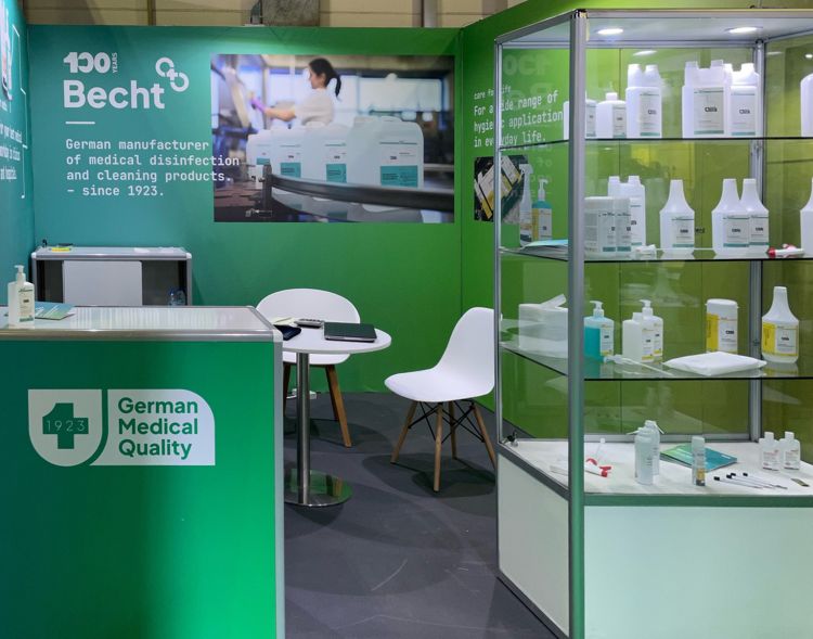 Messestand der Alfred Becht GmbH mit grünem Design, Glasvitrine mit Desinfektions- und Reinigungsprodukten sowie dem Schriftzug „German Medical Quality – since 1923“.