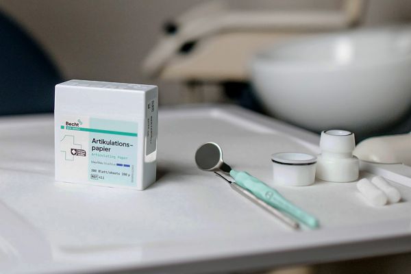 Dental tools and articulating paper on a tray, ready for a patient examinationDental tools and articulating paper on a tray, ready for a patient examination.